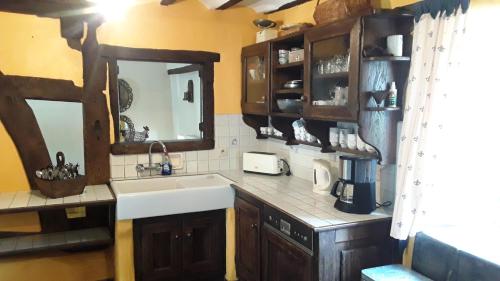 - une cuisine avec un évier et un miroir dans l'établissement Fermette Lejoly, à Waimes