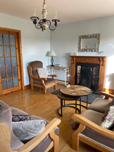 a living room with a couch and a fireplace at Rose Cottage in Killarney