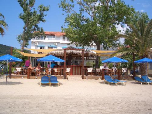 a group of chairs and umbrellas on the beach at Hercules Sea Front Studios in Katelios