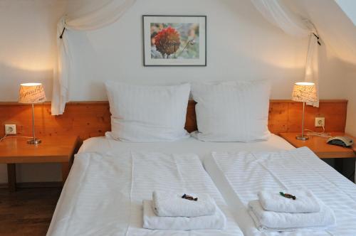 a bedroom with a white bed with towels on it at Pension Bella Vista in Bochum