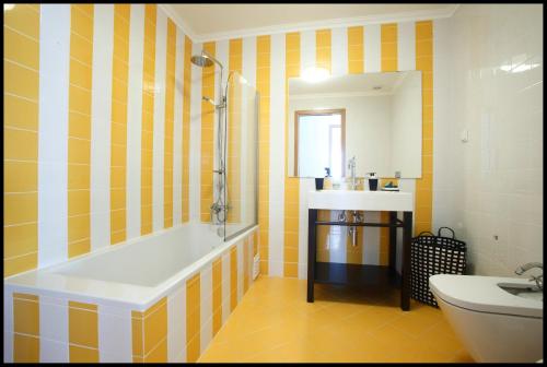 a bathroom with a tub and a sink at Casa do Joaquim da Praia in Nazaré