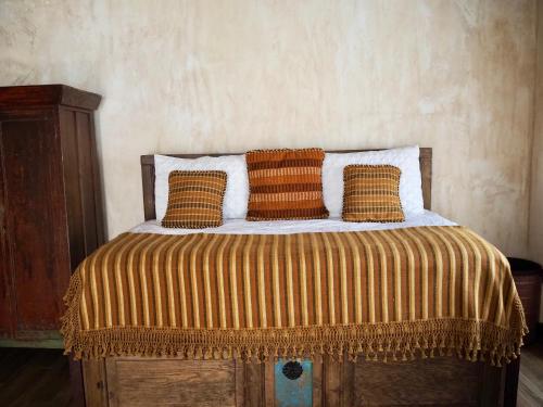 a bed with four pillows on top of it at Hotel Casa Madeleine B&B & Spa in Antigua Guatemala