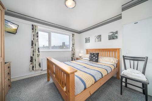 a bedroom with a bed and a chair and a window at Deneside Guest House in Blackpool
