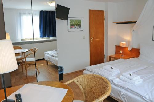a hotel room with a bed and a table and a mirror at Pension Bella Vista in Bochum