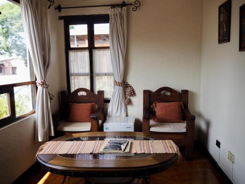 a living room with a table and chairs and a window at Hotel Casa Madeleine B&B & Spa in Antigua Guatemala