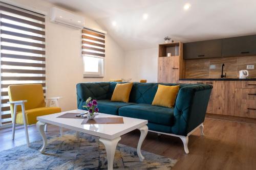 a living room with a blue couch and a table at Heaven Premium apartments in Sarajevo