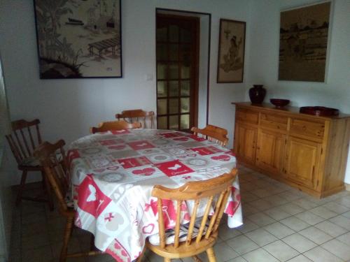 une table à manger avec un tissu de table rouge et blanc dans l'établissement LA HETRAIE, à Vergetot