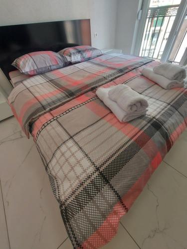 a bed with two pillows on top of it at XXL APARTMENTS CiTY CENTAR in Bitola