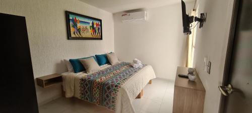 1 dormitorio con 1 cama con almohadas azules en Moderno depa con terraza y vista extraordinaria en Manzanillo