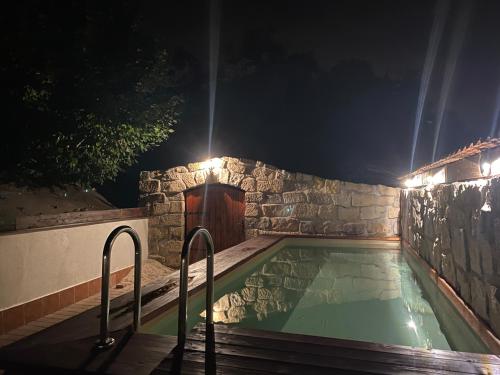 una piscina por la noche con una puerta de madera en SG chalupa ŠTIKOV - Podkrkonoší - s celoročním privátním wellness en Nová Paka