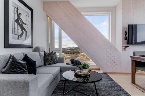 a living room with a couch and a table at MJOS TOWER Apartment - Lovely city view in Ringsaker