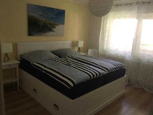 a large bed in a bedroom with a window at FEWO Ostsee Oase in Eckernförde
