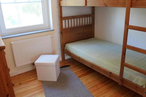 a bedroom with two bunk beds and a window at Strandvilla Sophie App 1 in Dierhagen