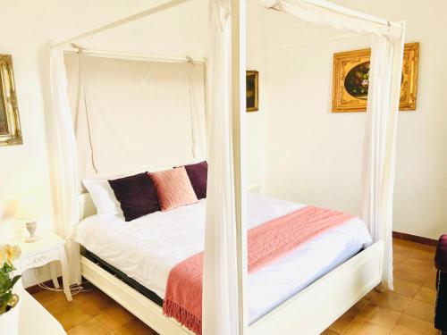 una camera con un letto a baldacchino bianco di Medieval Cosy Getaway a Giuliano di Roma