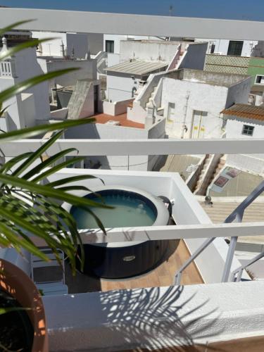 a tub on a balcony with a view of a city at Casa Paixanita - jacuzzi & terrace downtown Olhao in Olhão