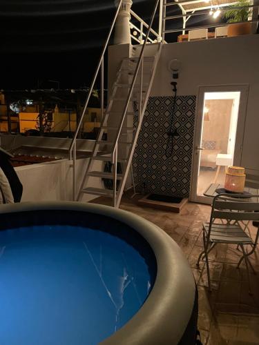 a hot tub on a cruise ship with a table and stairs at Casa Paixanita - jacuzzi & terrace downtown Olhao in Olhão