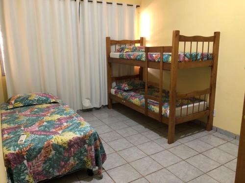 a bedroom with a bed and a bunk bed and a shelf at Oncotô Palmas Hostel in Palmas