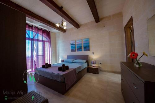 - une chambre avec un lit et une grande fenêtre dans l'établissement Ta Marija, à Żebbuġ