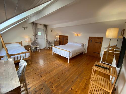 an attic bedroom with two beds and wooden floors at Quaint 4 Bed Barn Conversion Barnhouse Starshinezz in Trimdon Grange