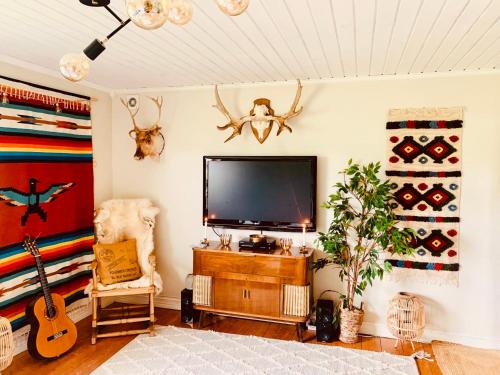 uma sala de estar com uma televisão de ecrã plano na parede em Super cosy cottage in heart of Dalarna em Västra Fors
