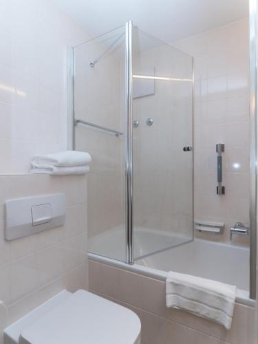 a white bathroom with a shower and a toilet at Appartement-Hotel Seespitz in Füssen