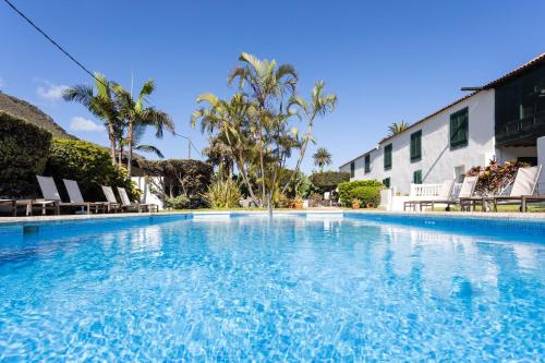 una gran piscina con sillas y un edificio en Hotel El Patio, en Garachico