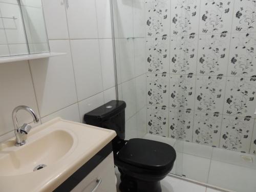 a bathroom with a black toilet and a sink at Espaço Canastra in Delfinópolis