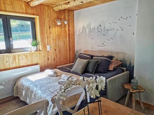 um quarto com uma cama, um sofá e uma mesa em La cachette du Ballon - cote-montagnes em Altenbach
