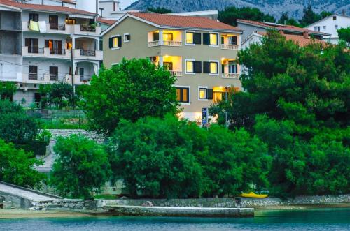 a building next to a body of water with trees at Villa Lidija in Omiš