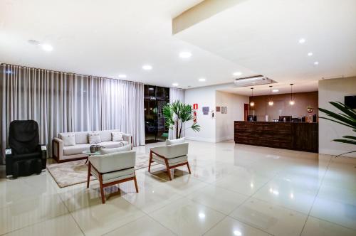 a living room with a couch and a table and chairs at Go Inn Contagem - MG in Contagem