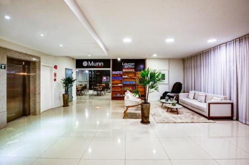an office lobby with a couch and a table at Go Inn Contagem - MG in Contagem