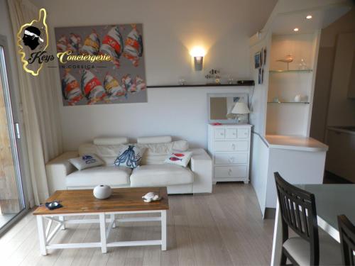 een woonkamer met een bank en een tafel bij Résidence Cala Sultana N62 - 4 pers avec Piscine chauffée- accès privé à la Plage de SANTA GIULIA in Porto-Vecchio