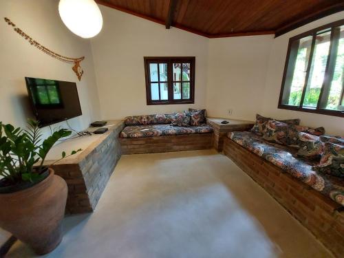 una gran sala de estar con sofás y TV. en Porto do Meio, en Arraial d'Ajuda