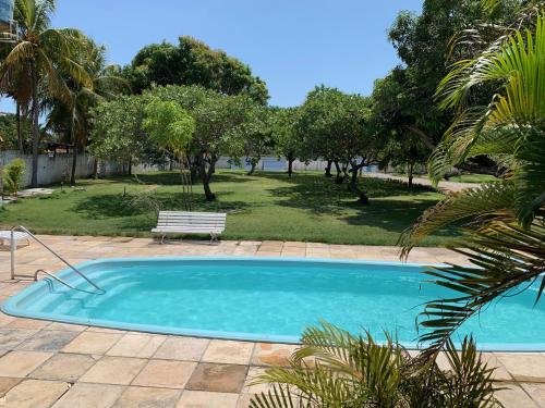 ein Schwimmbad mit einer Bank in einem Park in der Unterkunft CASA LAGOA DO BANANA/CUMBUCO in Caucaia