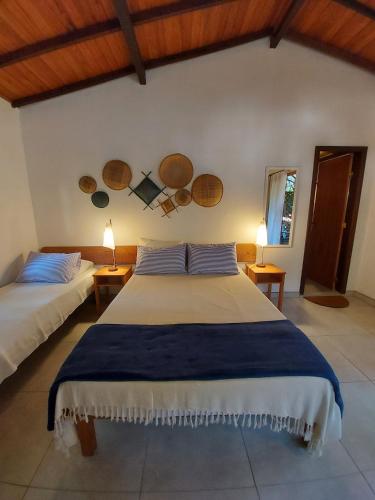 a bedroom with two beds and two lamps at Porto do Meio in Arraial d'Ajuda