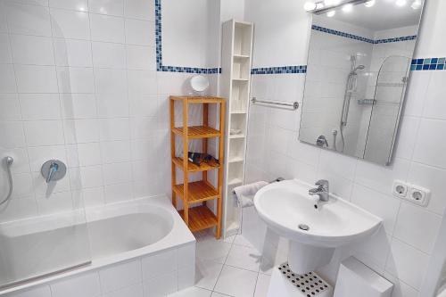 biała łazienka z umywalką, wanną i prysznicem w obiekcie Freesenkietz, FW 24 w Zingst