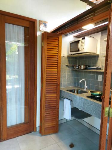 a kitchen with a sink and a microwave at Porto do Meio in Arraial d'Ajuda