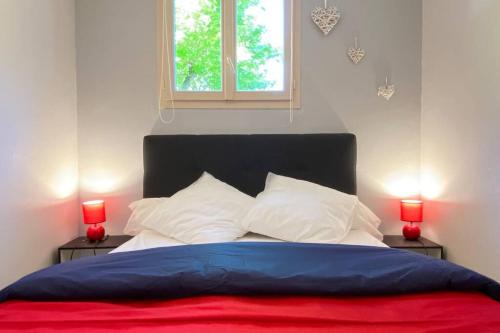 科特雷的住宿－T2 ensoleillé. Terrasse et vaste jardin commun，一间卧室配有一张带两个红灯的床