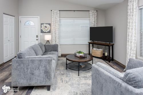 a living room with two couches and a flat screen tv at Susitna Suites in Wasilla