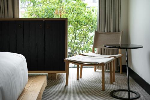a room with a bed, chair, table and a lamp at TRUNK (HOTEL) in Tokyo