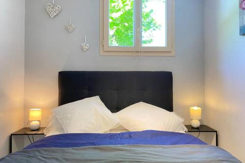 una camera da letto con un letto con due luci su due tavoli di T2 ensoleillé. Terrasse, jardin commun, vue, parking. a Cauterets