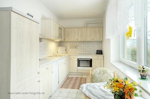 a kitchen with white cabinets and a table and a window at Wolf, Barbara, FW 6 in Zingst