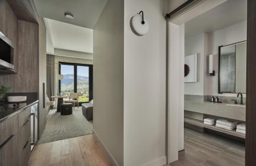 a hallway of a bathroom with a sink and a mirror at Pendry Park City in Park City