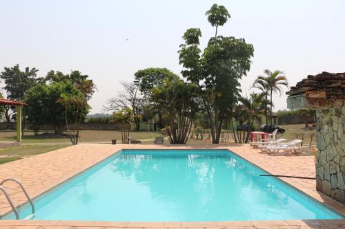 a large blue swimming pool in a yard at Pousada Chácara Sonho in Hortolândia