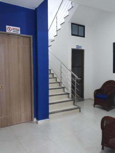 a set of stairs in a building with a blue wall at Hotel Central in Sincelejo