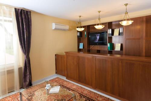 uma sala de espera com uma televisão de ecrã plano e uma televisão de ecrã plano em Pension Palazzo em Sibiu