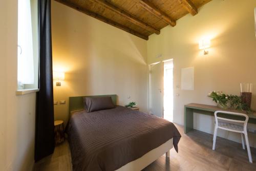 a bedroom with a bed and a table and a window at Agriturismo La Galizia in Cuggiono
