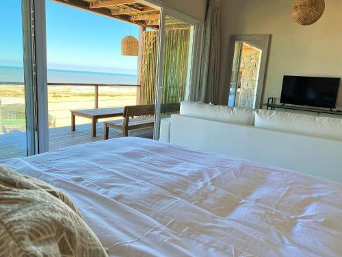 Schlafzimmer mit einem Bett und Meerblick in der Unterkunft Ojos de la Viuda in Punta Del Diablo