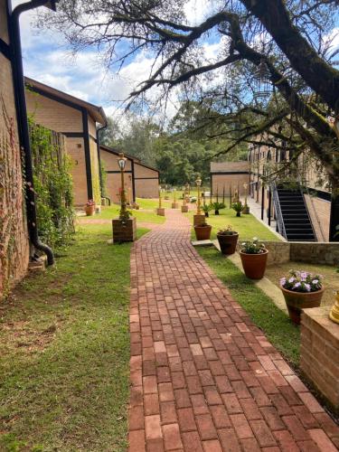 a brick walkway in a yard next to a building at LA PIANTA - Uma experiência na Villa de Monte Verde in Monte Verde