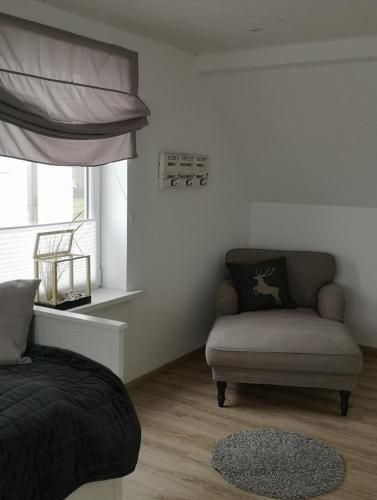 sala de estar con sofá, silla y ventana en Black Pearl, en Schönberger Strand